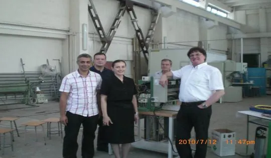 Fotografie de grup a cinci participanți într-un atelier cu utilaje, la seminarul AGFR din București, 12–13 iulie 2010