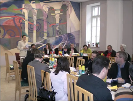 Participanți așezați la masa de lucru în sala de conferințe, la lansarea Codului Bunelor Practici, martie 2009